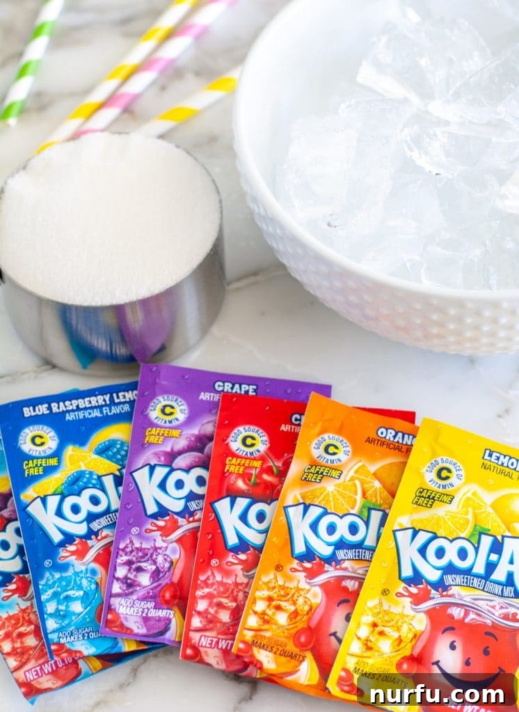 Crafting Your Perfect Slushie 3 Collection of Kool-Aid packets in various flavors, a bowl filled with ice cubes, and a measuring cup of sugar, ready for blending.