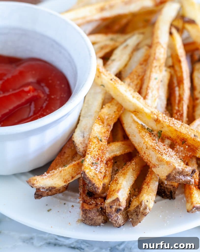 Plate of french fries with bowl of ketchup