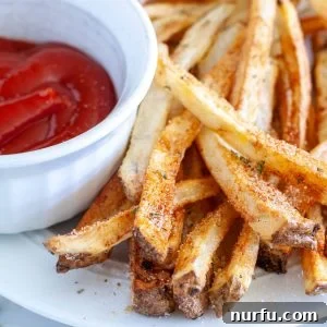 French fries on plate with ketchup.