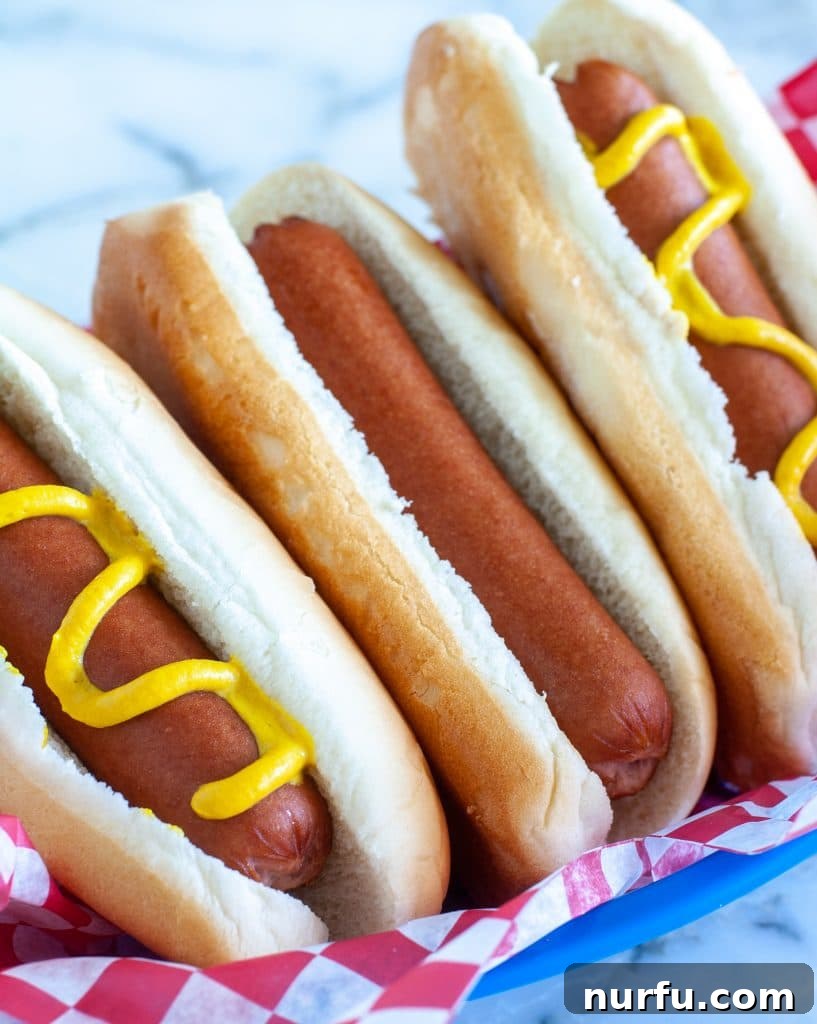 Mastering the Boiled Hot Dog 4 Three hot dogs nestled in a blue basket with fries