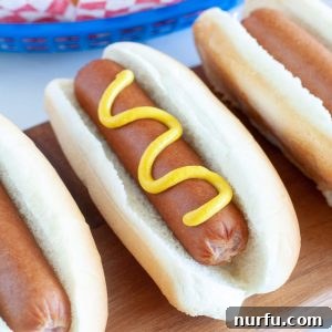 hot dog on a board with mustard