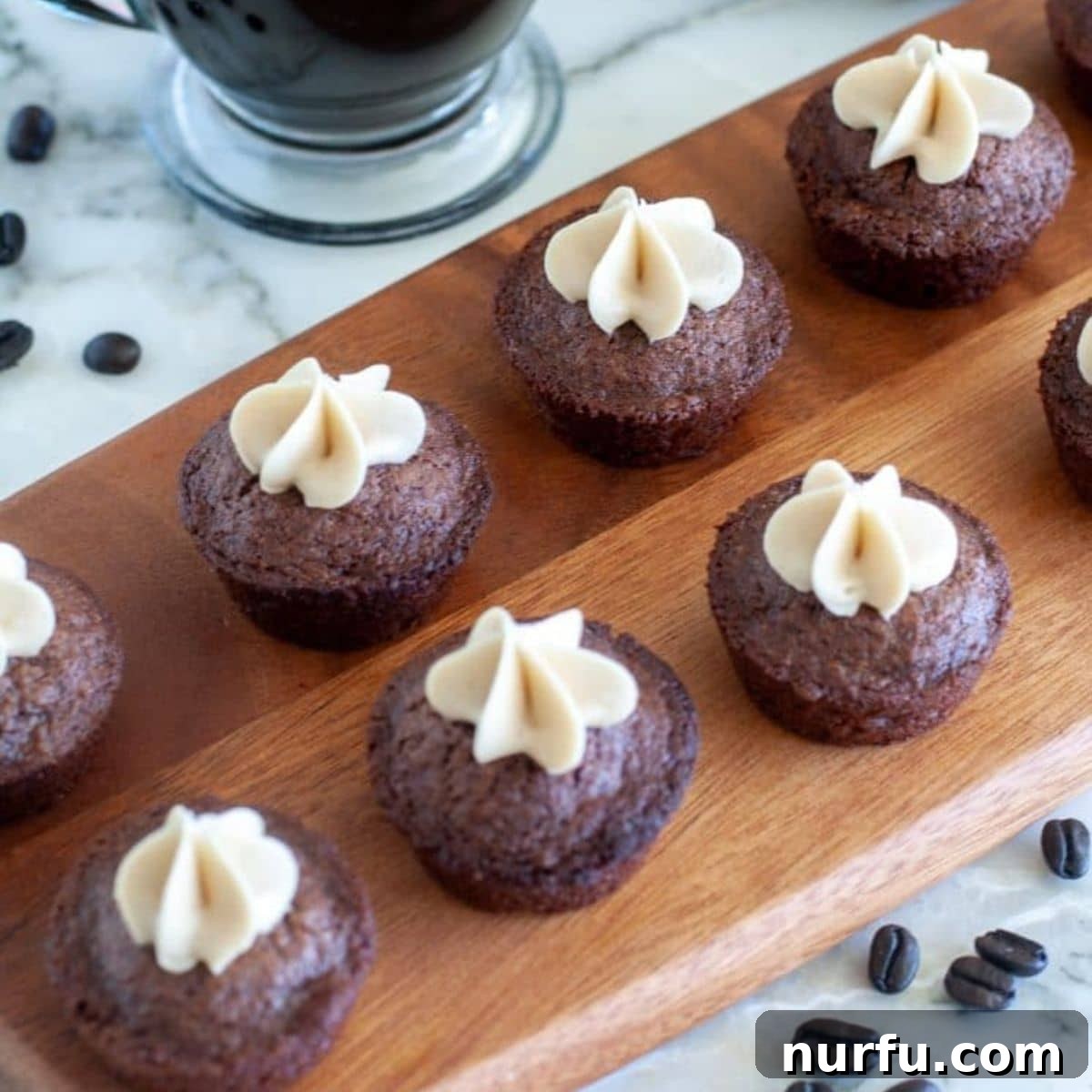 Coffee Kick Brownie Bites 5 Elegant cutting board showcasing several frosted Espresso Brownie Bites, ready to be enjoyed.