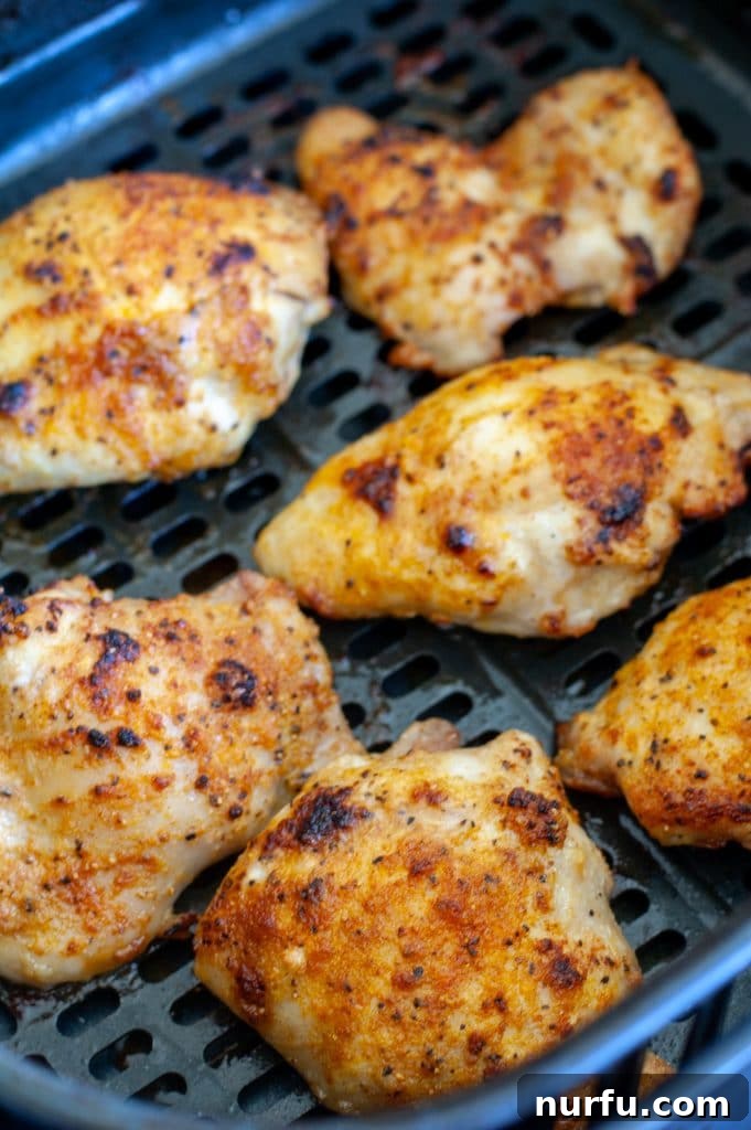 The Ultimate Air Fryer Chicken Thighs 4 cooked chicken thighs in air fryer basket