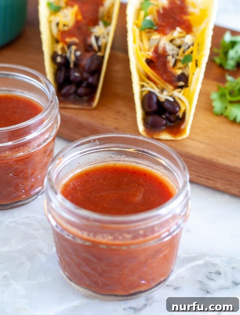Fiesta Flavor Sauce 2 Taco sauce in a jar with tacos in back, showcasing a homemade condiment ready for use.