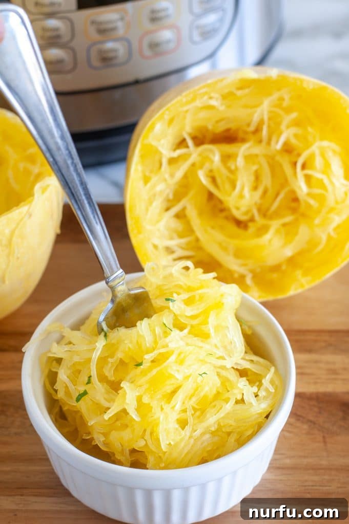 Easy Instant Pot Spaghetti Squash 4 Close-up of a fork scooping tender spaghetti squash strands from a white bowl, garnished with fresh parsley