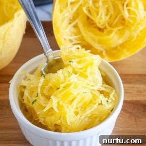 Fork in bowl of cooked spaghetti squash, ready to eat