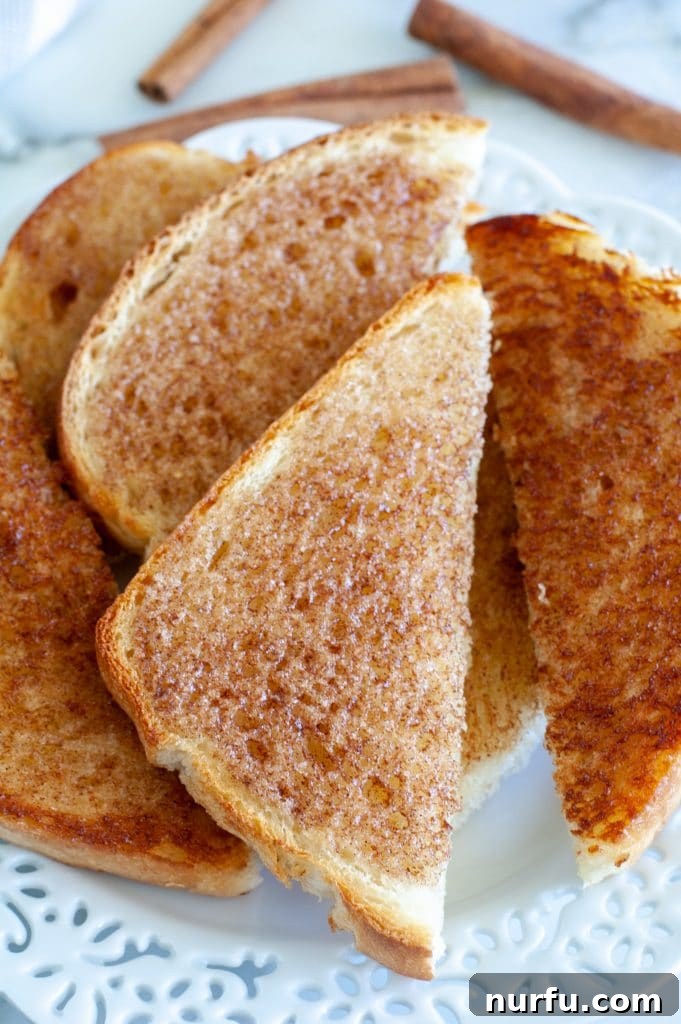 Choose Your Crunch: Three Ways to Make Cinnamon Toast 2 Perfectly golden cinnamon toast slices on a white plate, ready to be enjoyed.