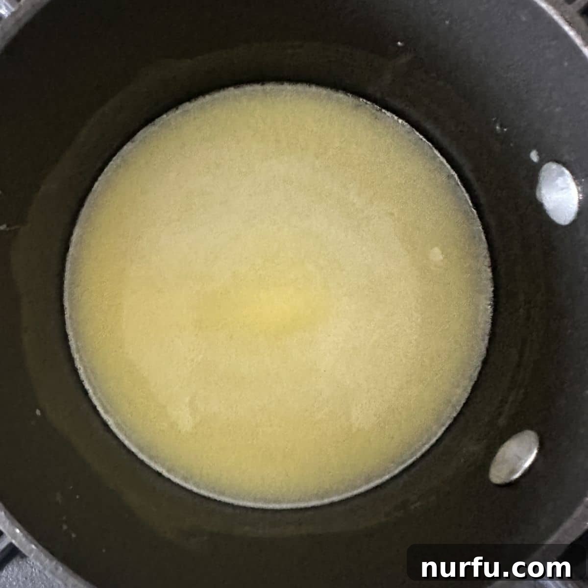 Easy Homemade Buffalo Sauce 4 A saucepan on the stove with a pool of perfectly melted butter, ready for the next steps of making buffalo sauce.