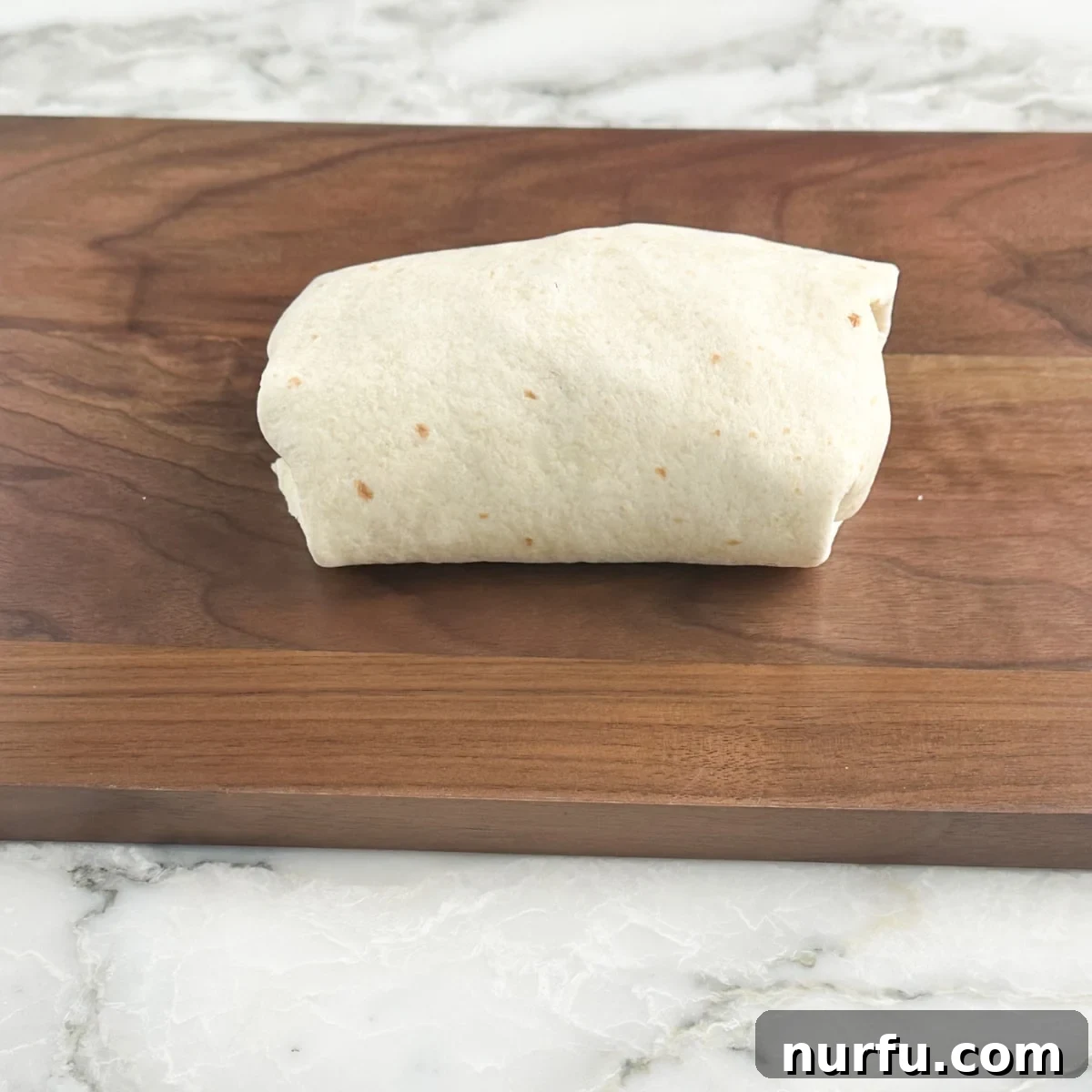 Zesty Buffalo Chicken Wraps 7 Wrap on a cutting board.