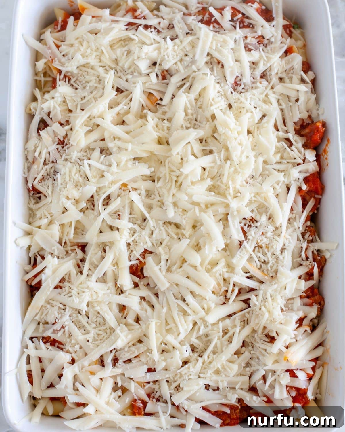 Cheesy Baked Mostaccioli 7 Adding the remaining pasta and sauce, topped with shredded mozzarella and Parmesan cheese.