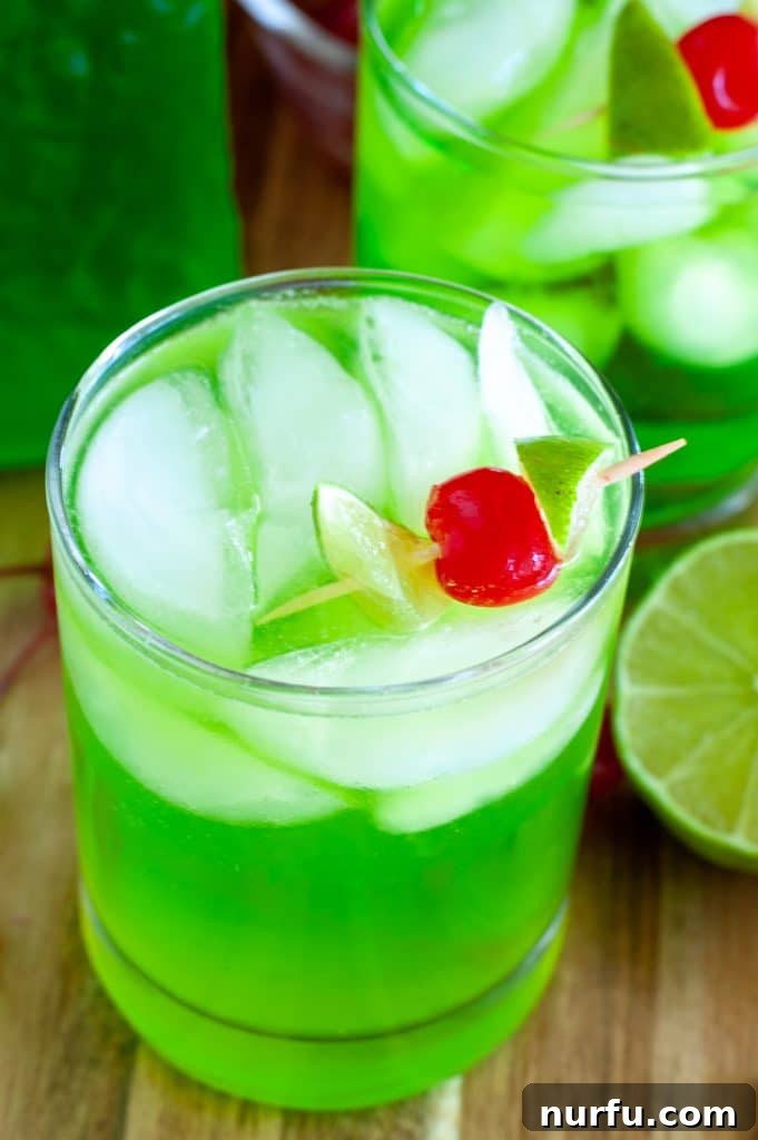 A perfectly poured Midori Sour cocktail in a clear glass, showing its vibrant green color against a subtly blurred background, ready to be enjoyed.