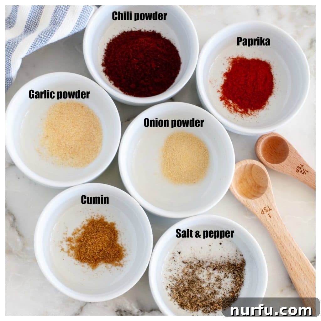 Craft Your Own Chili Spice Blend 3 Collection of white bowls filled with individual spices like chili powder, paprika, and cumin.