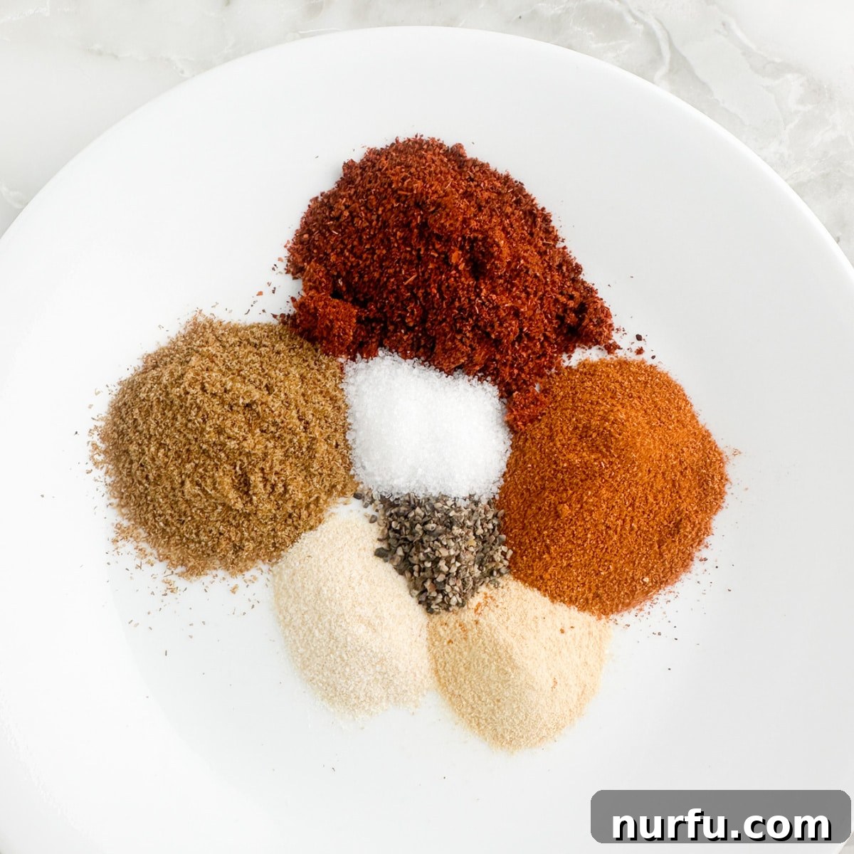 Craft Your Own Chili Spice Blend 4 A small plate showcasing the freshly mixed homemade chili seasoning, ready for use.