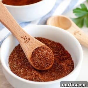 Bowl of chili seasoning and wooden teaspoon.