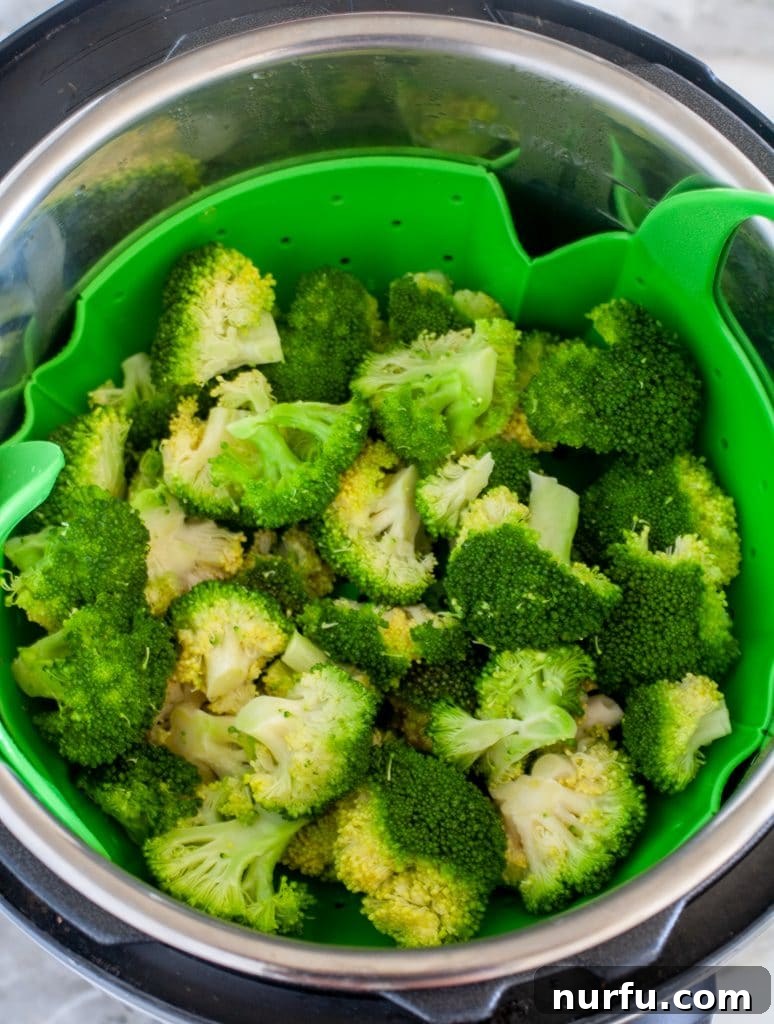 Quick and Tender Instant Pot Broccoli 2 Broccoli florets arranged in a pressure cooker steamer basket, ready for steaming.