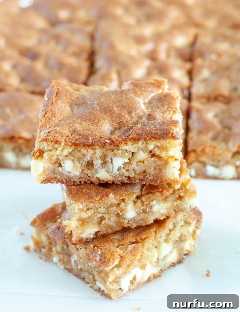 Delicious blonde brownies stacked on each other, showcasing their chewy texture and golden color