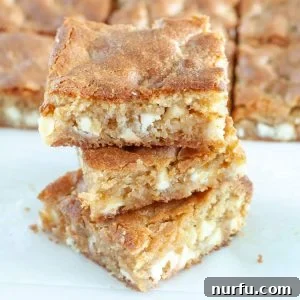 Blonde Brownies stacked on each other, showing their golden color and tempting texture