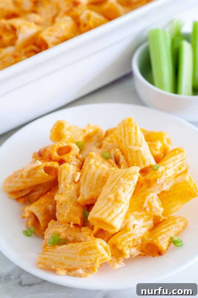 Buffalo chicken pasta bake on a plate with celery in a bowl