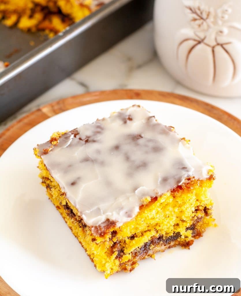 Autumn Spiced Pumpkin Coffee Cake 4 Close-up of a slice of pumpkin coffee cake on a white plate, showing the moist crumb and cinnamon swirl.