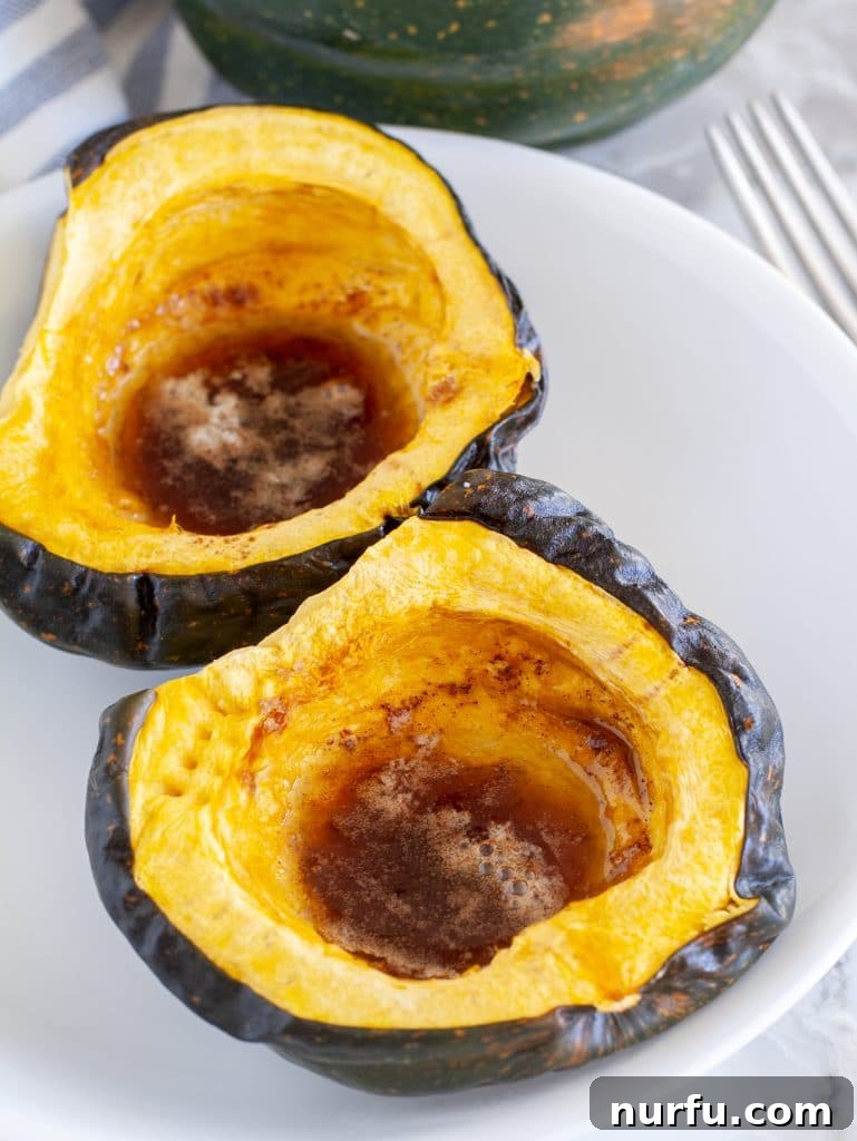 Easy Microwave Acorn Squash 2 Perfectly cooked acorn squash halves on a white plate, seasoned and ready to serve