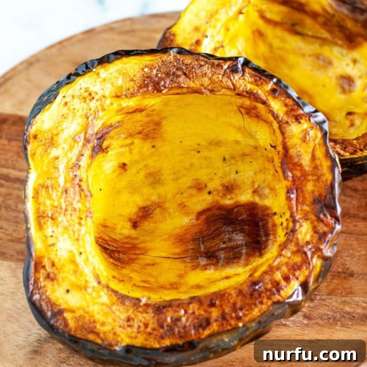 Savory and Sweet Air Fryer Acorn Squash 2 Perfectly roasted acorn squash halves, glistening with seasoning, ready to be served.