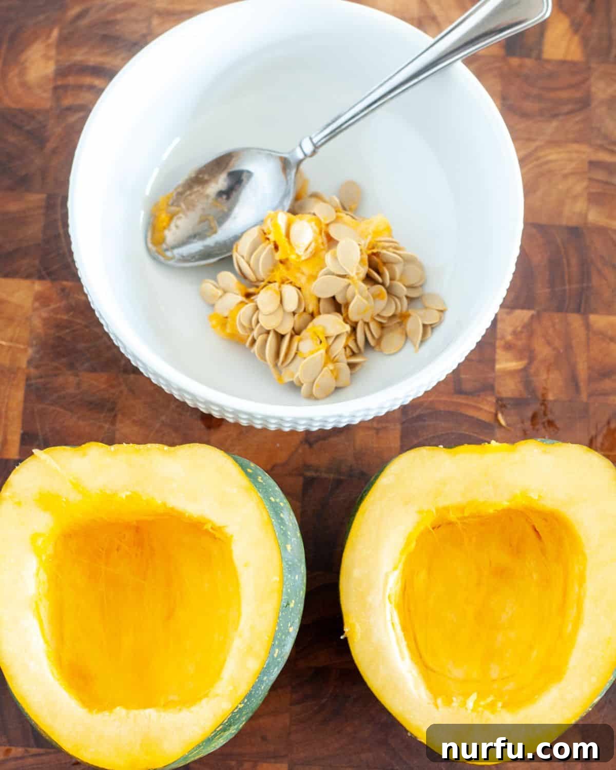 Savory and Sweet Air Fryer Acorn Squash 3 A freshly halved acorn squash with a separate bowl of scooped-out seeds, illustrating the preparation step.