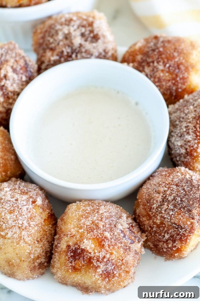 Plate of golden-brown cinnamon pretzel bites with white icing drizzle