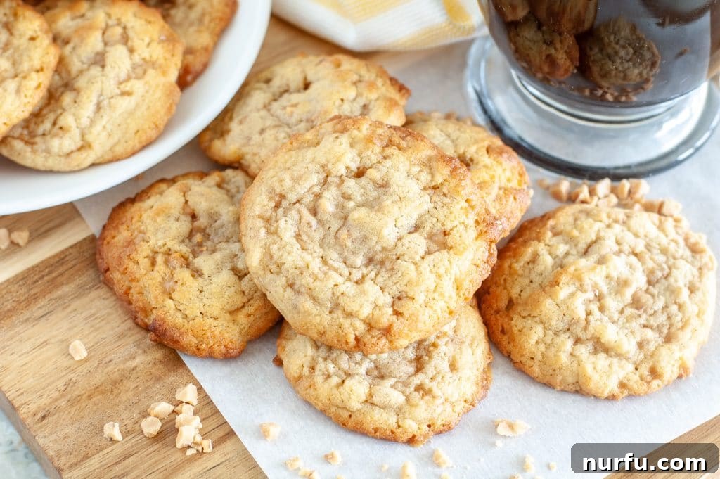 A charming stack of coffee toffee cookies nestled on wax paper, with a steaming coffee cup in the soft-focus background, evoking a cozy, inviting atmosphere.