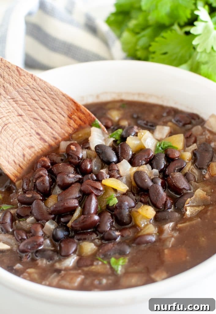 Black beans with a wooden spoon in a bowl