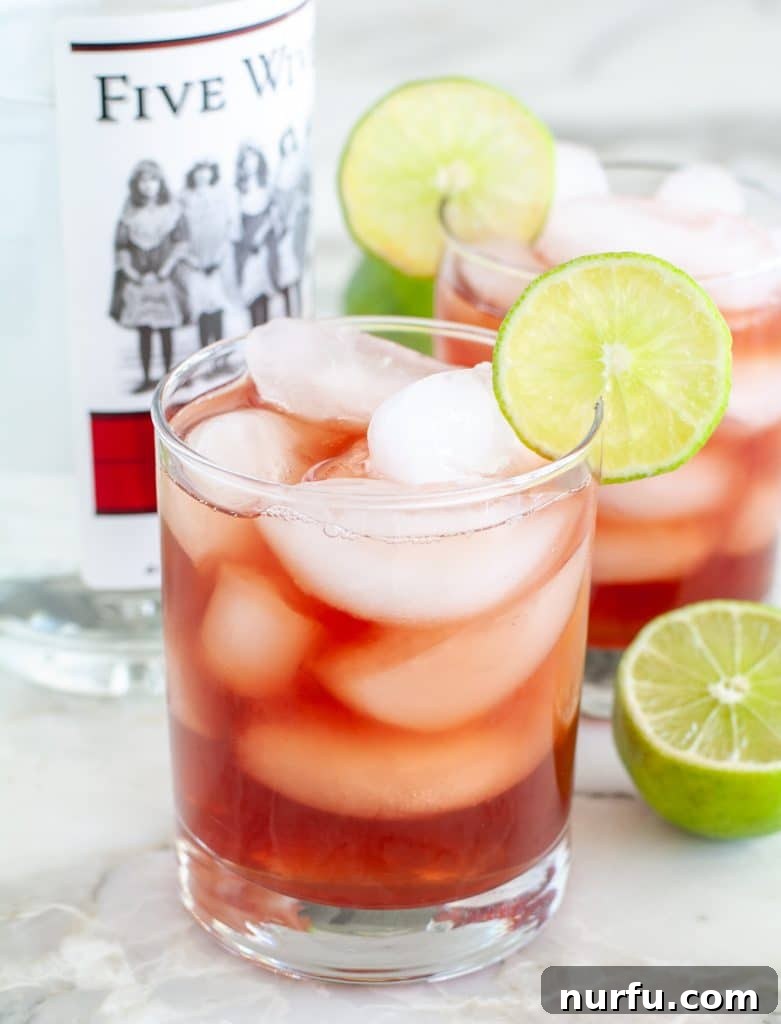 Vibrant red vodka cranberry cocktail with lime garnish