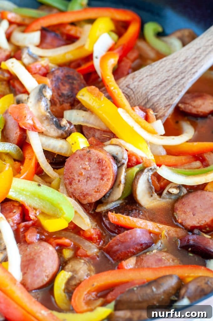 Hearty Polish Sausage Skillet 4 Wooden spoon with sausage and peppers.