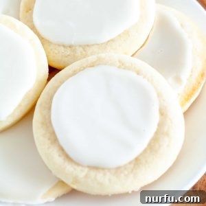 Soft sour cream cookies with frosting on a plate, ready to be enjoyed
