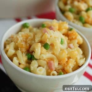Macaroni and Cheese with ham and peas in bowl.