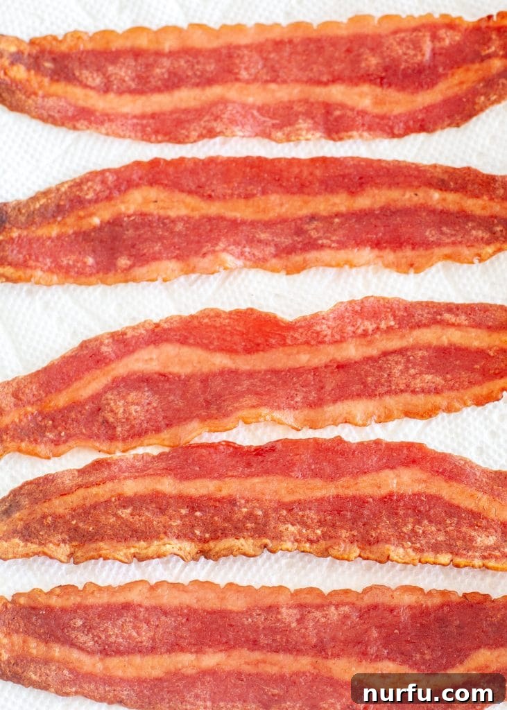 Golden Crispy Air Fryer Turkey Bacon 2 Cooked turkey bacon slices perfectly crispy on a plate.