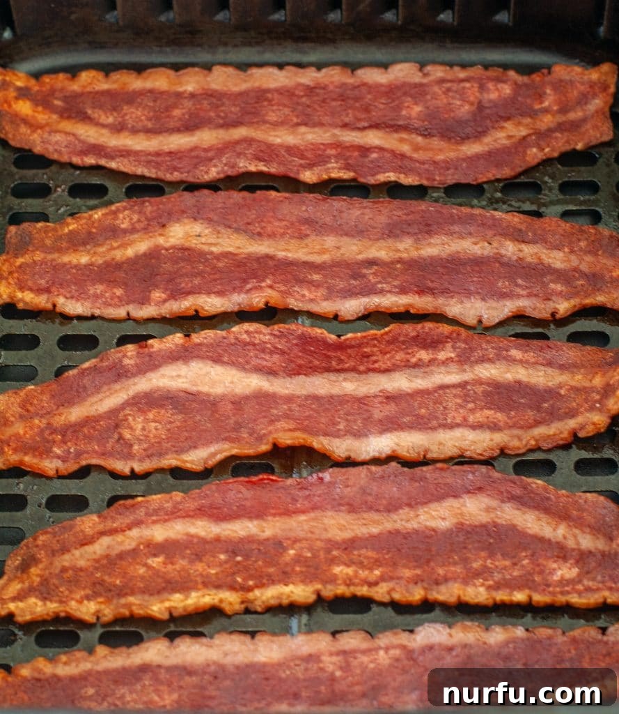 Golden Crispy Air Fryer Turkey Bacon 4 Perfectly cooked, crispy turkey bacon in an air fryer basket.