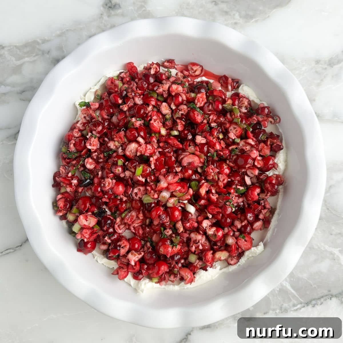 Cranberry jalapeno dip beautifully assembled in a pie dish, ready to serve.