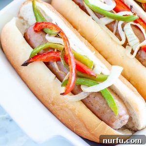 Bratwurst in a bun with onions and peppers, a classic way to enjoy oven-baked brats.