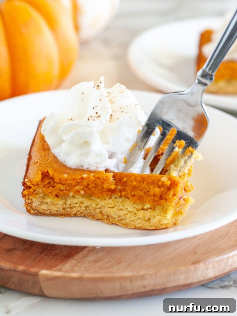 A fork taking a piece of gooey pumpkin butter cake from a plate, showing its rich, soft texture.