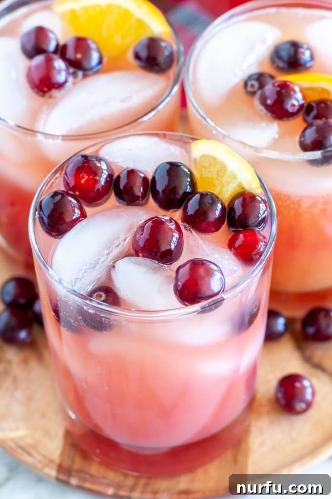 Glass with holiday punch on a plate with Christmas decorations.