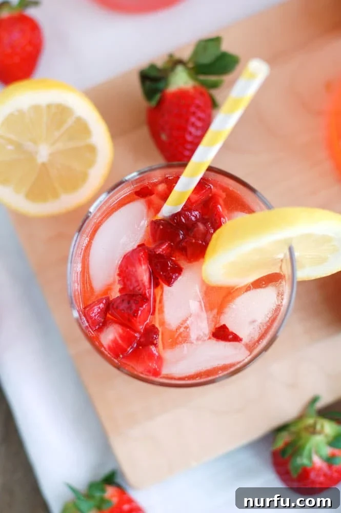 - The BEST strawberry lemonade. Made with fresh lemon juice and strawberries, everyone will love this recipe! Top view of glass with strawberry lemonade and strawberries and lemon beside the glass.