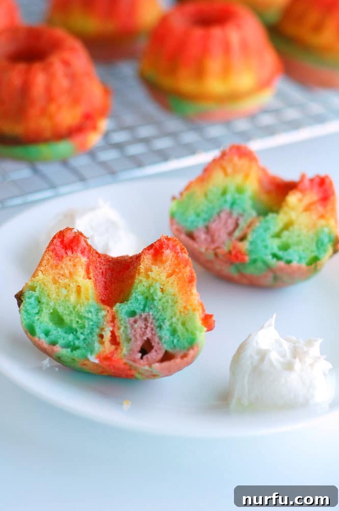 Vibrant rainbow bundt cakes topped with marshmallow frosting, ready for a celebration.
