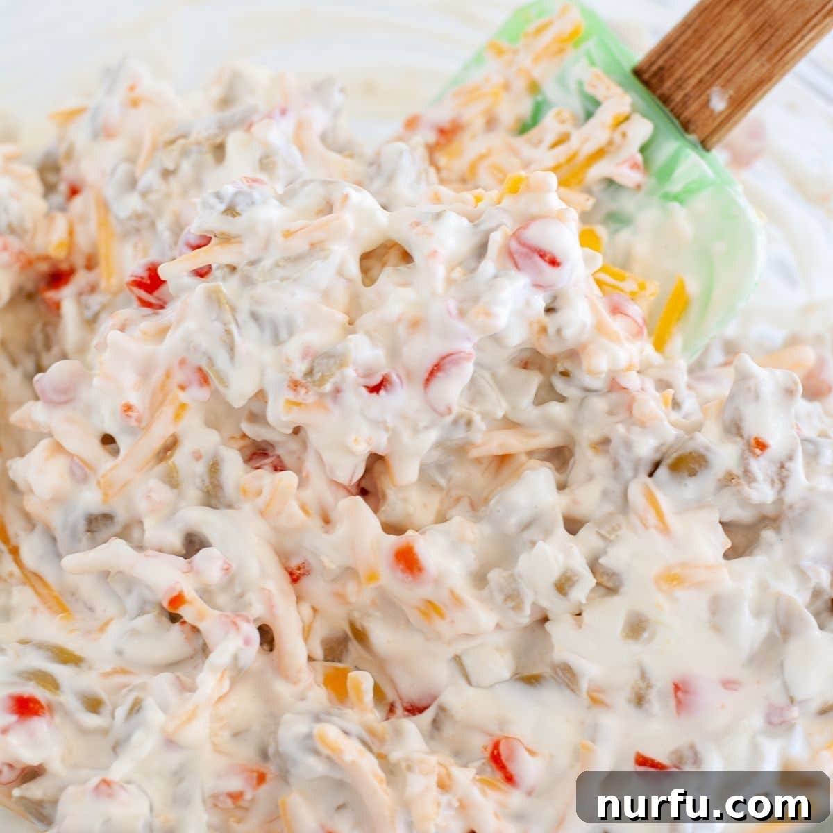A pristine bowl of perfectly blended creamy green olive dip, its surface smooth and inviting, hinting at the rich flavors within, ready to be served as an irresistible appetizer.
