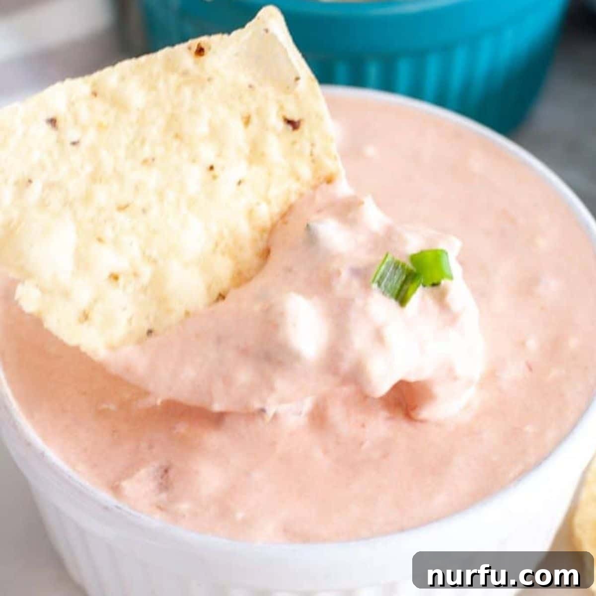 Ultimate Cream Cheese Salsa Dip 6 A beautifully presented bowl of creamy cream cheese salsa dip, perfectly scooped onto a tortilla chip, ready for enjoyment.