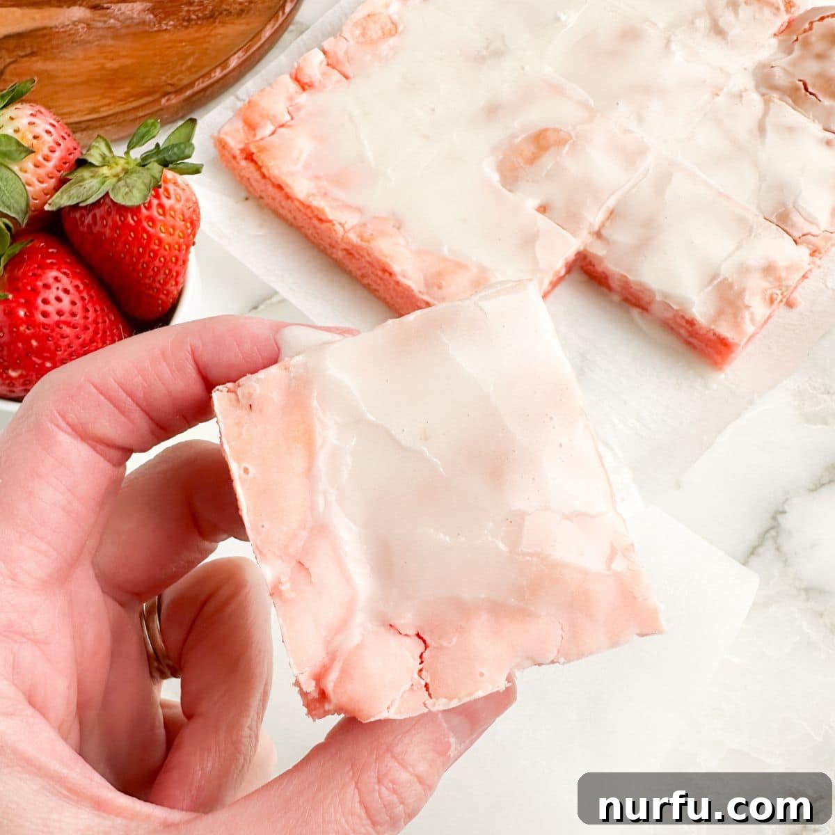 Effortless Strawberry Cake Mix Squares 8 Hand holding a strawberry brownie.