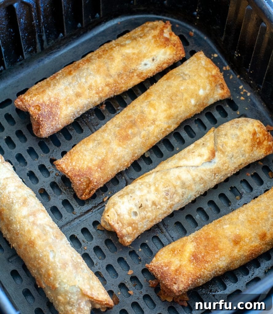 Air Fryer Crispy Egg Rolls: From Freezer to Fantastic 4 Egg rolls in an air fryer basket.