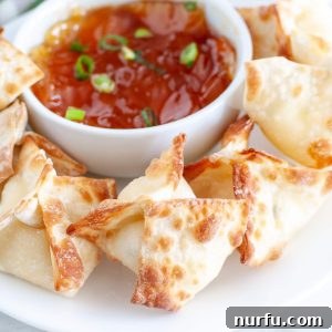 Wontons on plate with bowl of sauce.