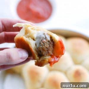 Molten Meatball Pockets 2 Hand holding meatball wrapped in bread and sauce.