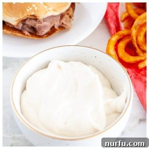 A beautifully presented bowl of creamy Horsey Sauce, ready to accompany a succulent roast beef sandwich.