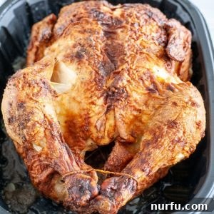 Chicken in a black container, showcasing reheated rotisserie chicken.