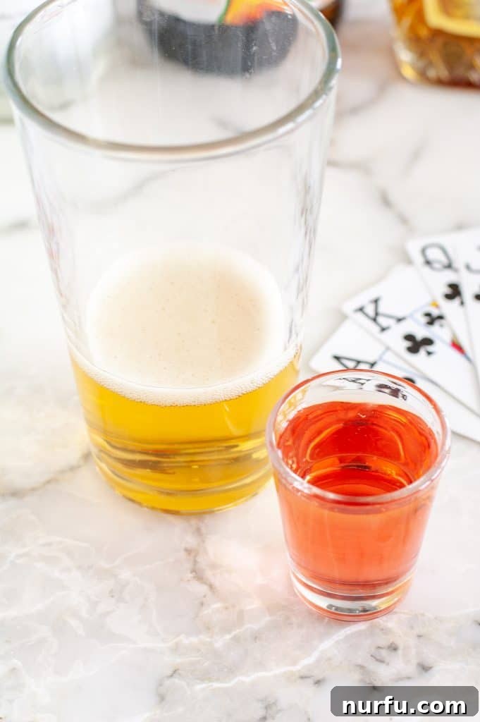 Ignite Your Night: The Vegas Bomb Cocktail 5 A large glass filled with a sparkling energy drink, with a shot glass containing vibrant liquor dropped inside, ready for consumption.